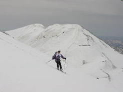 湯殿山をバックに快適大斜面を滑る