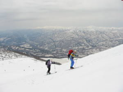 朝日連峰をバックに登る